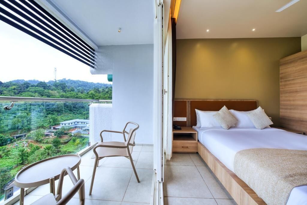 A hotel room with a balcony, a bed, a bedside table, and a chair.