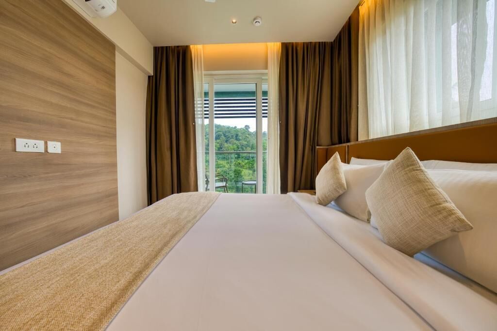 Une chambre d’hôtel avec un grand lit, une vue par la fenêtre et un mur en bois.