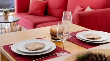 Une table à manger dressée avec des assiettes, un verre de vin et une bougie.