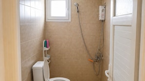 A small bathroom with a toilet, a bidet, and a shower.