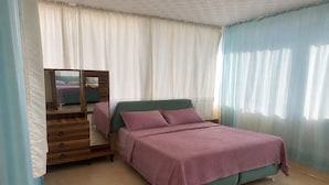A bedroom with a bed, a dresser, and a mirror.