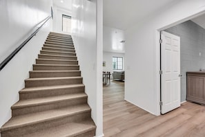Eine Treppe führt zu einem Wohnbereich mit Esstisch und Sofa.
