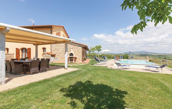 A house with a stone exterior, a covered patio with a table and chairs, a swimming pool with lounge chairs, and a view of the countryside. - Nice home in Lajatico with private swimming pool, can be inside or outside (Lajatico)