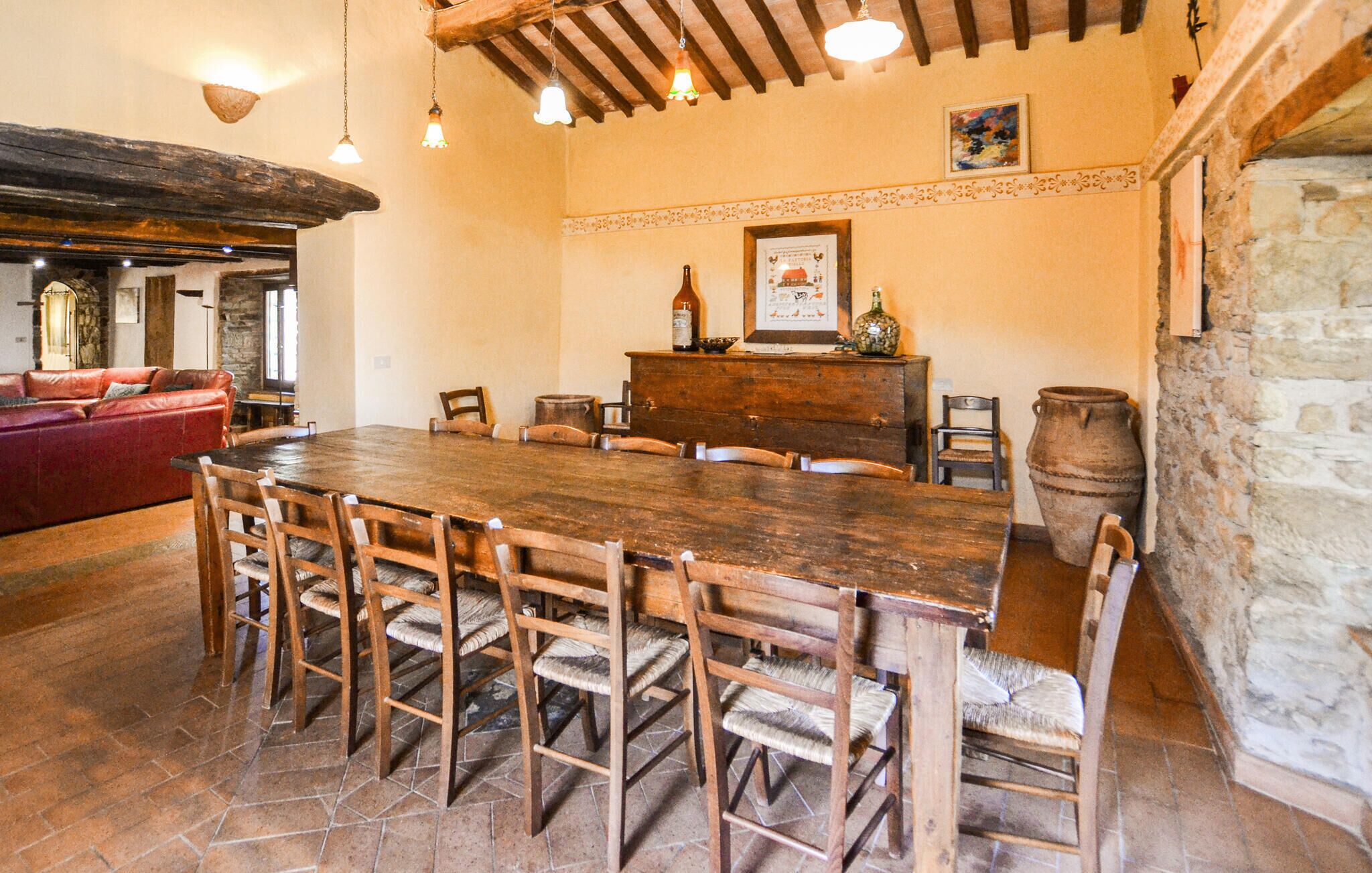 Un coin repas rustique avec une table et des chaises en bois, un mur en pierre et une cheminée.