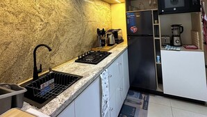 Una cocina moderna con encimera de granito, electrodomésticos de acero inoxidable y microondas integrado.