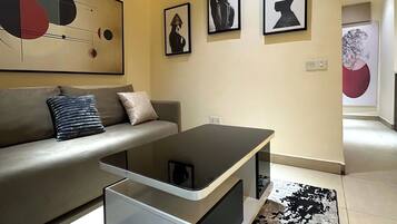A modern living room with a sofa, a coffee table, and artwork on the walls.