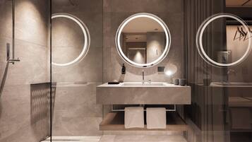 A modern bathroom with a glass shower enclosure, a vanity with a mirror, and a towel rack.