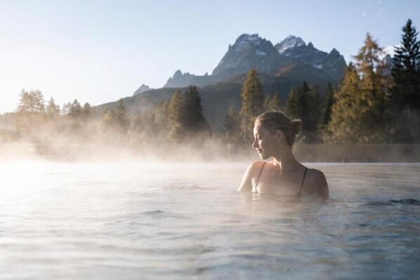 A person in a hot spring with a mountainous backdrop. - Hotel Monika - Adults Only (Sesto)