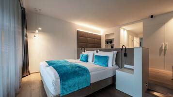 A modern bedroom with a bed, bedside tables, a built-in wardrobe, and a mirror.