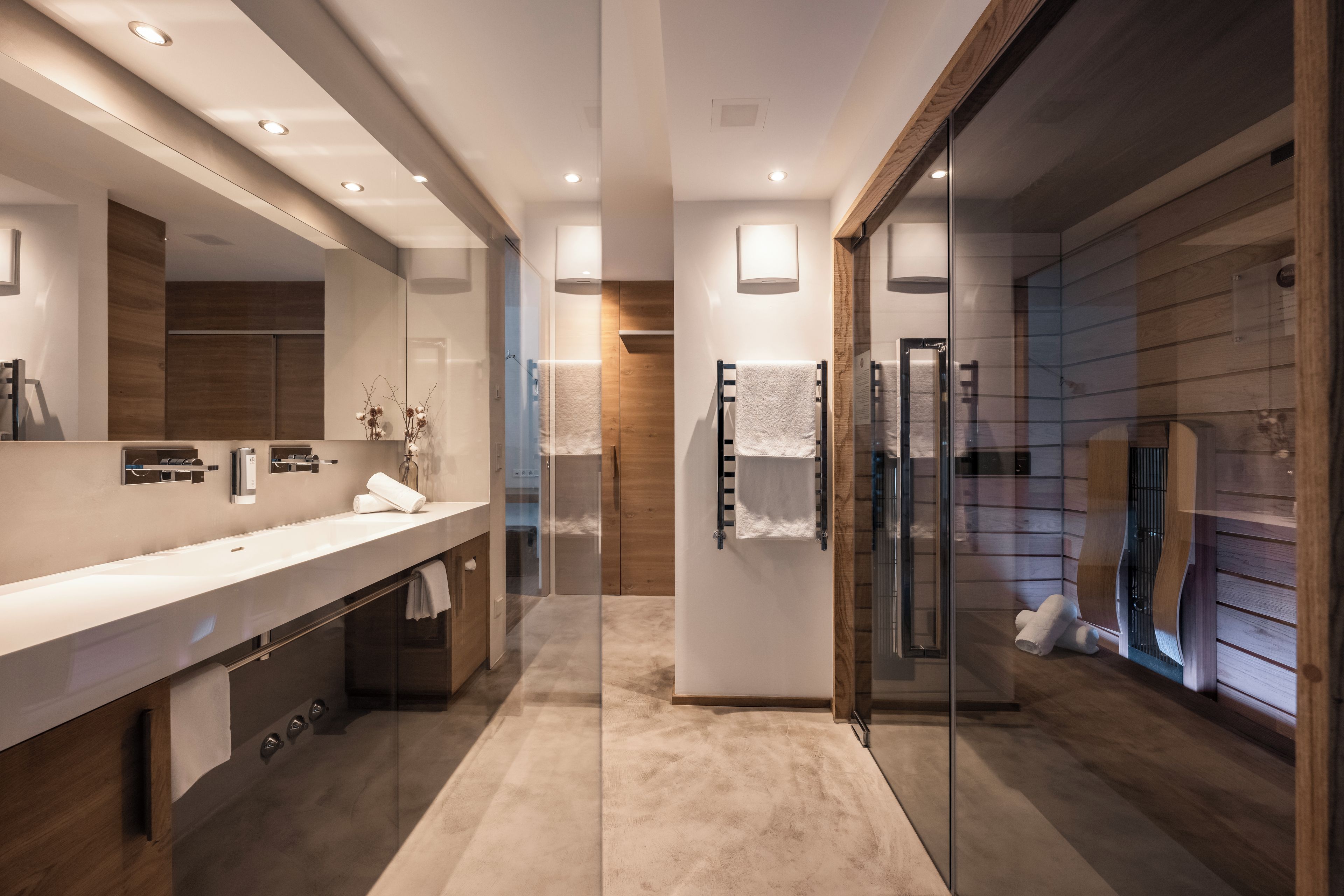 Une salle de bain moderne avec une douche à parois de verre, un grand miroir et un meuble-lavabo en bois.