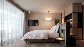 A modern bedroom with a bed, a TV, and a unique built-in shelving unit.