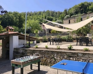 Espacio exterior con mesa de futbolín, mesa de ping pong y asientos al aire libre.
