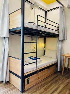 A bunk bed with a desk and a fan, number 8, in a room with wooden flooring. - Coral Riverside Homestay & Hostel (Da Nang)