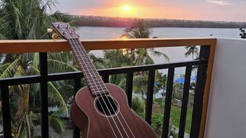 A guitar on a balcony with a sunset view.