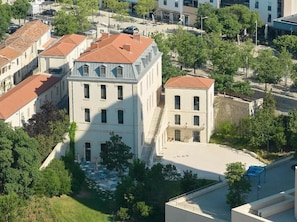 A building with a courtyard, surrounded by trees and other buildings.