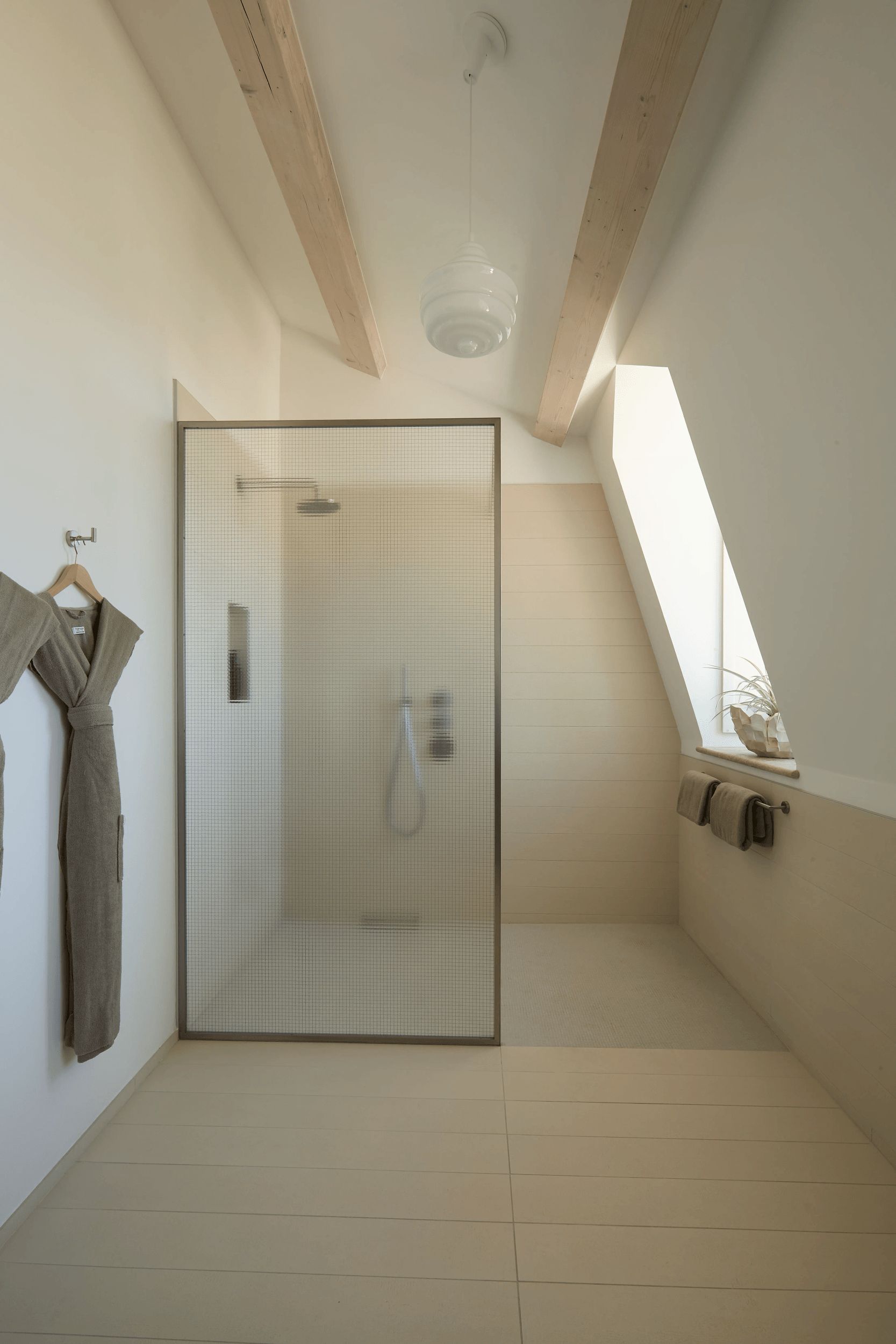 Une salle de bain moderne avec une douche, un porte-serviettes et une fenêtre.