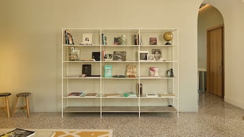 Une pièce avec une bibliothèque, un tapis à motifs et une porte en bois.