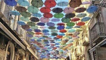 A street lined with buildings, covered by a canopy of umbrellas.