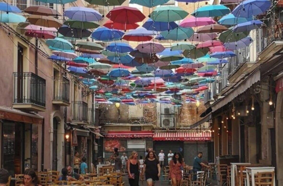 Una strada con diversi tavoli e sedie, che suggerisce una zona con posti a sedere all'aperto.