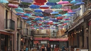 Une rue où l’on voit plusieurs tables et chaises, ce qui laisse supposer qu’il y a un espace aménagé pour s’asseoir à l’extérieur.
