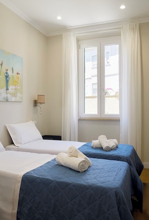 A hotel room with two beds, a painting on the wall, and a window with curtains. - Casa e Appartamento Vacanze Gallese 5 (Roma)