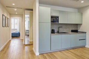 A modern kitchen with light blue cabinets, a Bosch microwave, and a sink. - Casa e Appartamento Vacanze Gallese 5 (Roma)