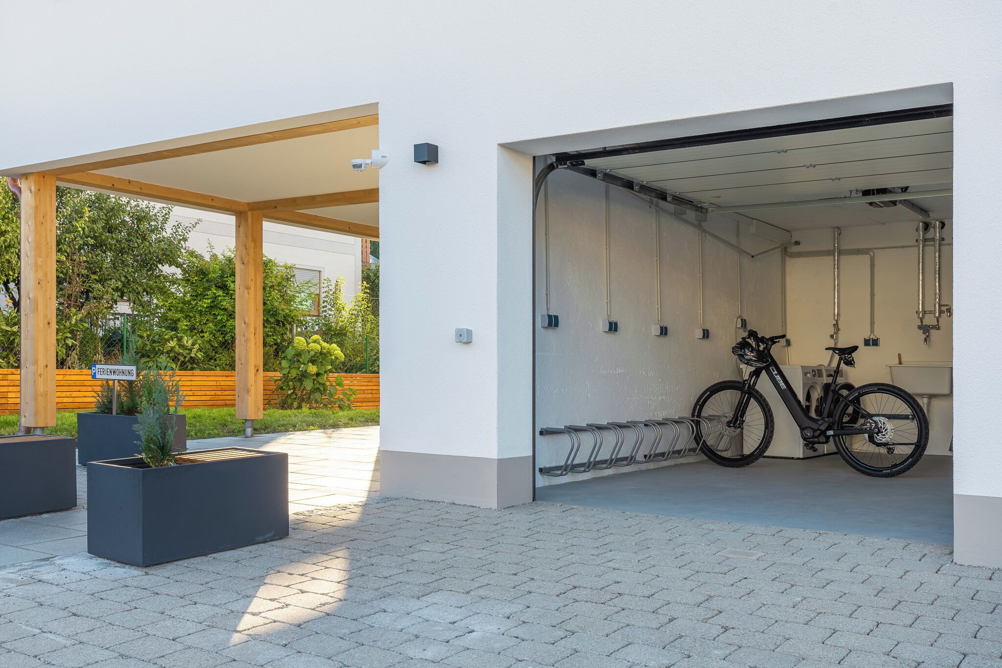 A covered outdoor area with a bicycle rack and a building entrance.