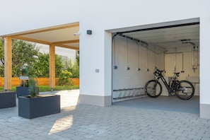 A covered outdoor area with a bicycle rack and a building entrance.