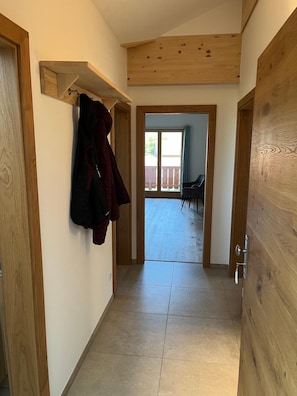 A hallway with wooden doors and a coat rack. - Hochgern Vacation Rental (Rottau)