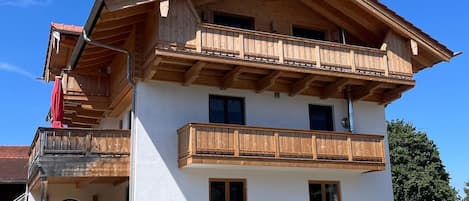 A two-story wooden building with balconies and a stone staircase leading to the entrance.