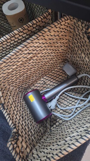 A woven basket containing a hairdryer and a power cord. - At Vale's House (Pescocostanzo)