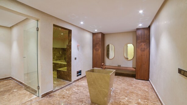 Un bagno moderno con cabina doccia in vetro, una vasca da bagno indipendente e due specchi fissati alla parete.