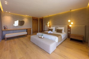 A modern hotel room with a large bed, bedside tables, a bench, and a mirror. - Villa Yasmine – Luxury villa with pools, hammam, and gym in Marrakech (Douar Moulay Abbas)