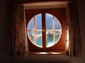A circular window with a view of a lake and buildings. - Bisang R Appartement/Fewo,   4-Bettwohnung by Interhome (Arosa)