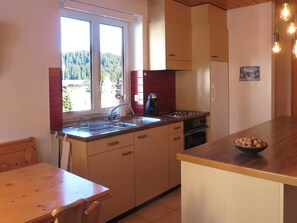 A kitchen with a window, a coffee maker, and a bowl of nuts on the counter. - Zum Rota Hus 7 Appartement/Fewo 4-Bettwohnung by Interhome (Arosa)