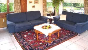 A room with two sofas, a table with fruit, and a patterned rug. - Casa Laghetto 5 Appartement/Fewo, Bad, WC, 4-Bettwohnung 4-Bettwohnung by Interhome (Arosa)