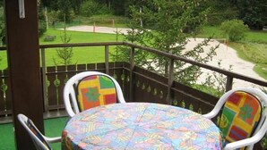 A covered outdoor seating area with a table and chairs, overlooking a mountainous landscape. - Casa Laghetto 5 Appartement/Fewo, Bad, WC, 4-Bettwohnung 4-Bettwohnung by Interhome (Arosa)