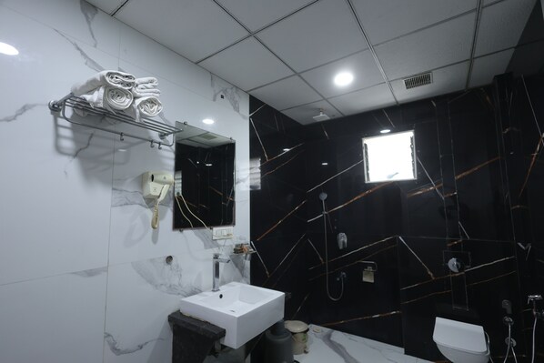 A modern bathroom with a white sink, a mirror, and a towel rack.