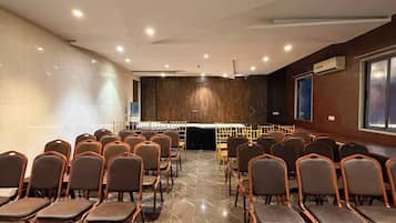 A conference room with rows of chairs, a podium, and a marble floor.