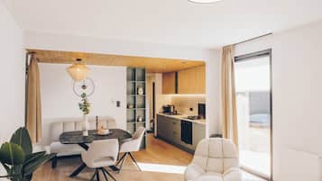 A modern living space with a dining area, kitchen, and seating area.