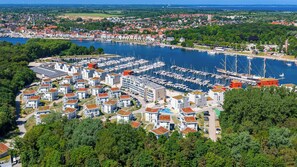 A marina with boats docked, surrounded by residential buildings with red roofs. - Dünenvilla 18, Apartment 05 (Lübeck-Travemünde)