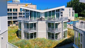 Um edifício moderno com várias varandas e janelas amplas.