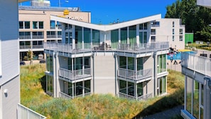 A modern building with multiple balconies and large windows. - Dünenvilla 18, Apartment 05 (Lübeck-Travemünde)