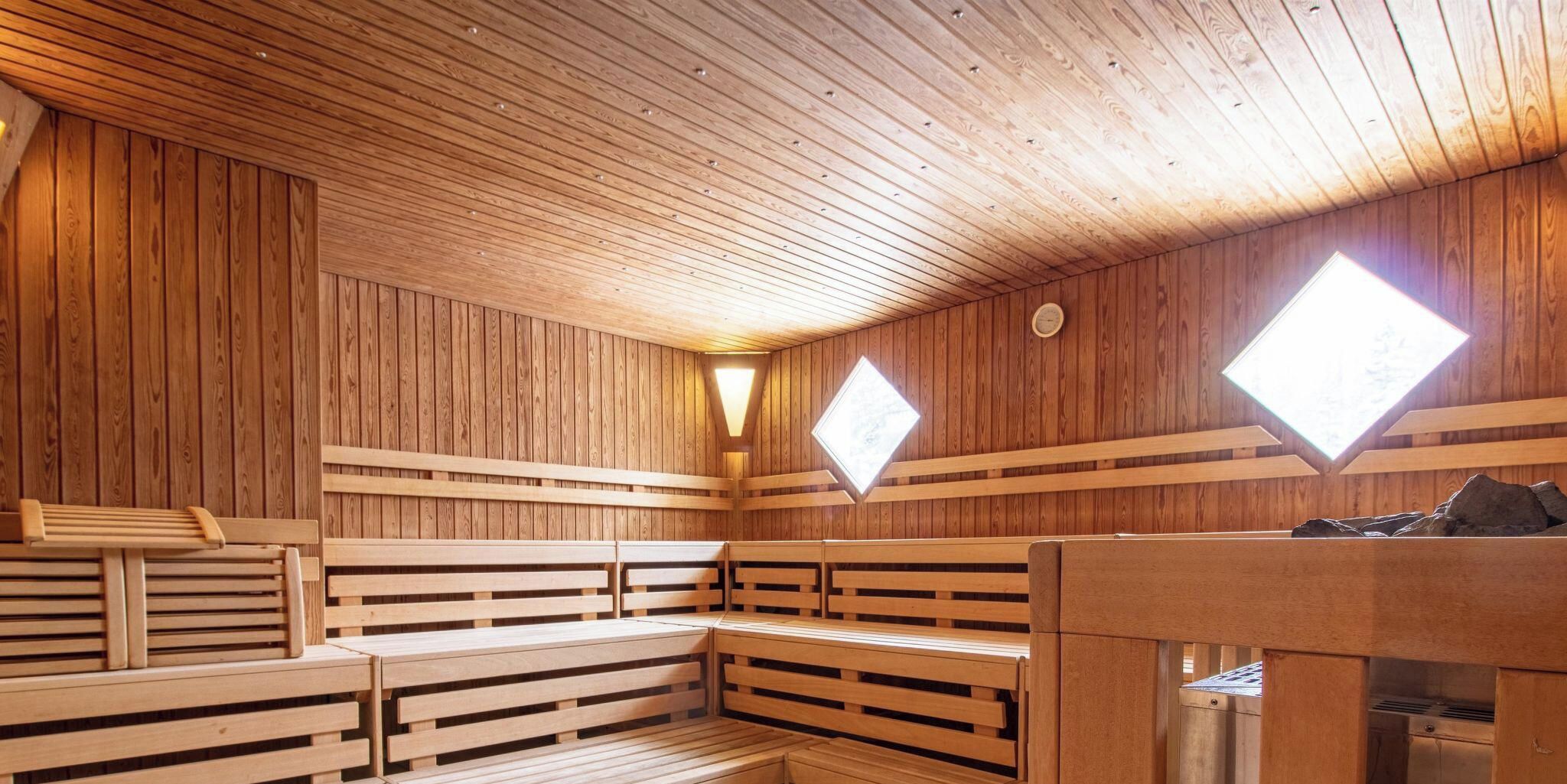 Una sauna amb seients de fusta i un banc de pedra.