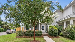 A residential house with a well-maintained lawn, a driveway, and a front porch. - The Reverie - Downtown Pensacola - Convenient Corner Lot - Great For Business Travelers - Fast WiFi (Pensacola)