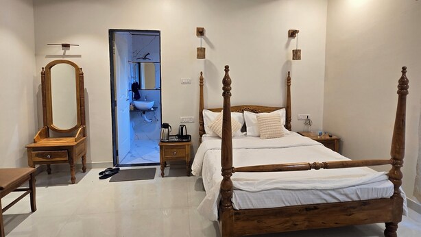 Quarto com cama de dossel, cômoda de madeira, penteadeira com espelho e ventilador de teto.