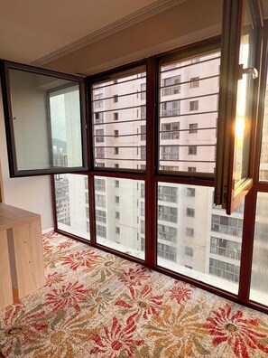A room with a large window, a patterned carpet, and a wooden cabinet. - Delightful 1-bedroom and 1 living room apartment near the city center in UB city (Ulaanbaatar)