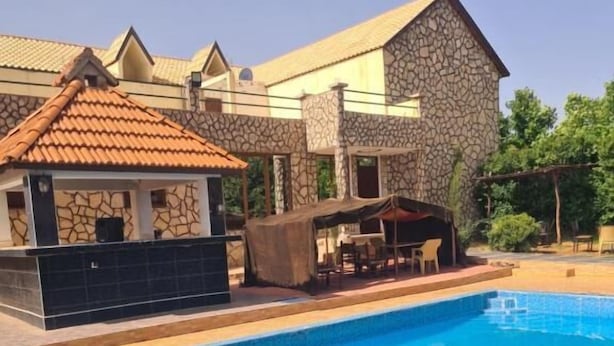 Una piscina con un edificio de piedra al fondo.