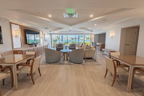A hotel lobby with a large television, seating area, and a view of the sea. - Park Shore-Luxury 3BR/3BA condo on Venetian Bay-boat slip, carport, private Park Shore beach pass (Naples)