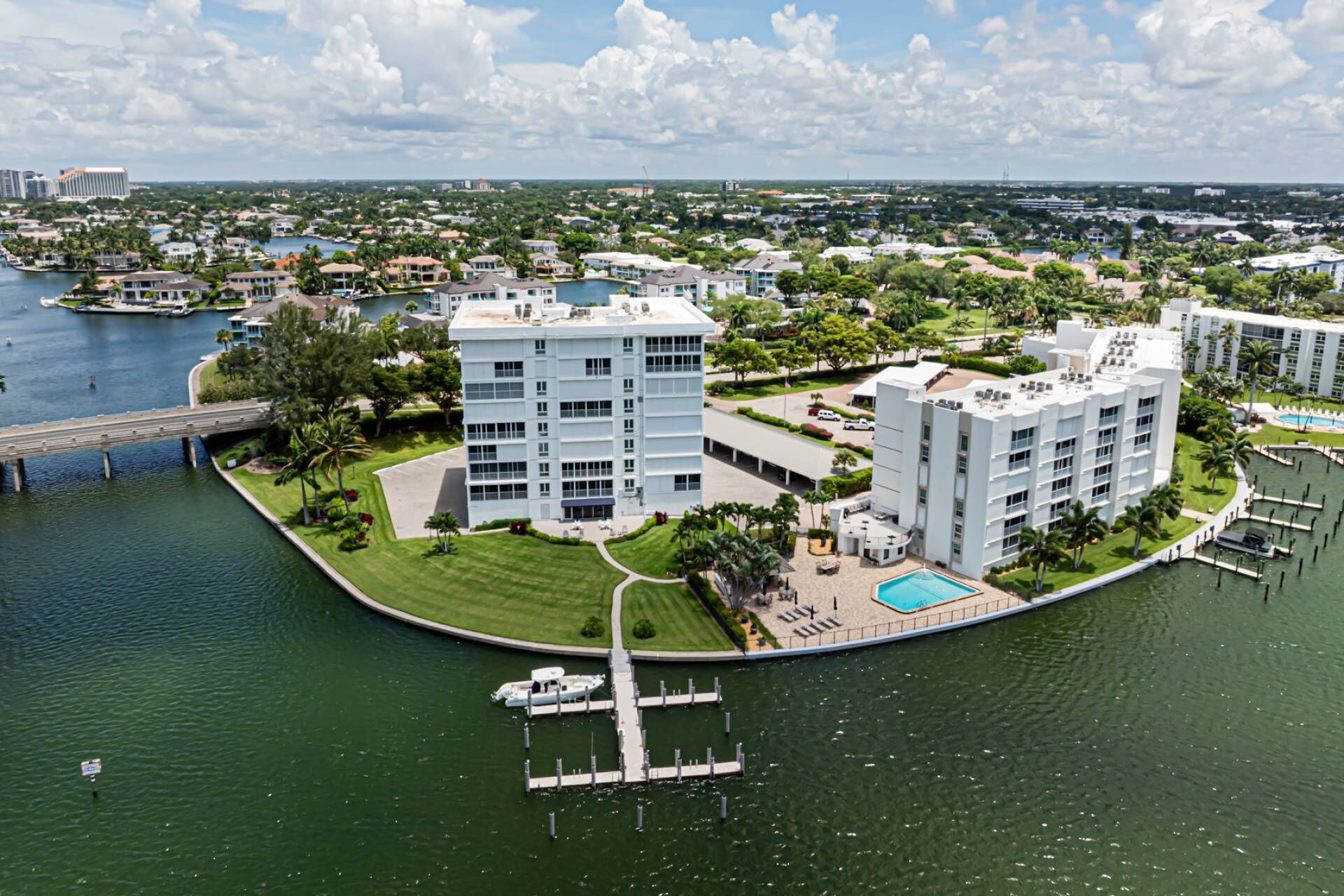 A waterfront hotel with multiple buildings, a dock, and a swimming pool.